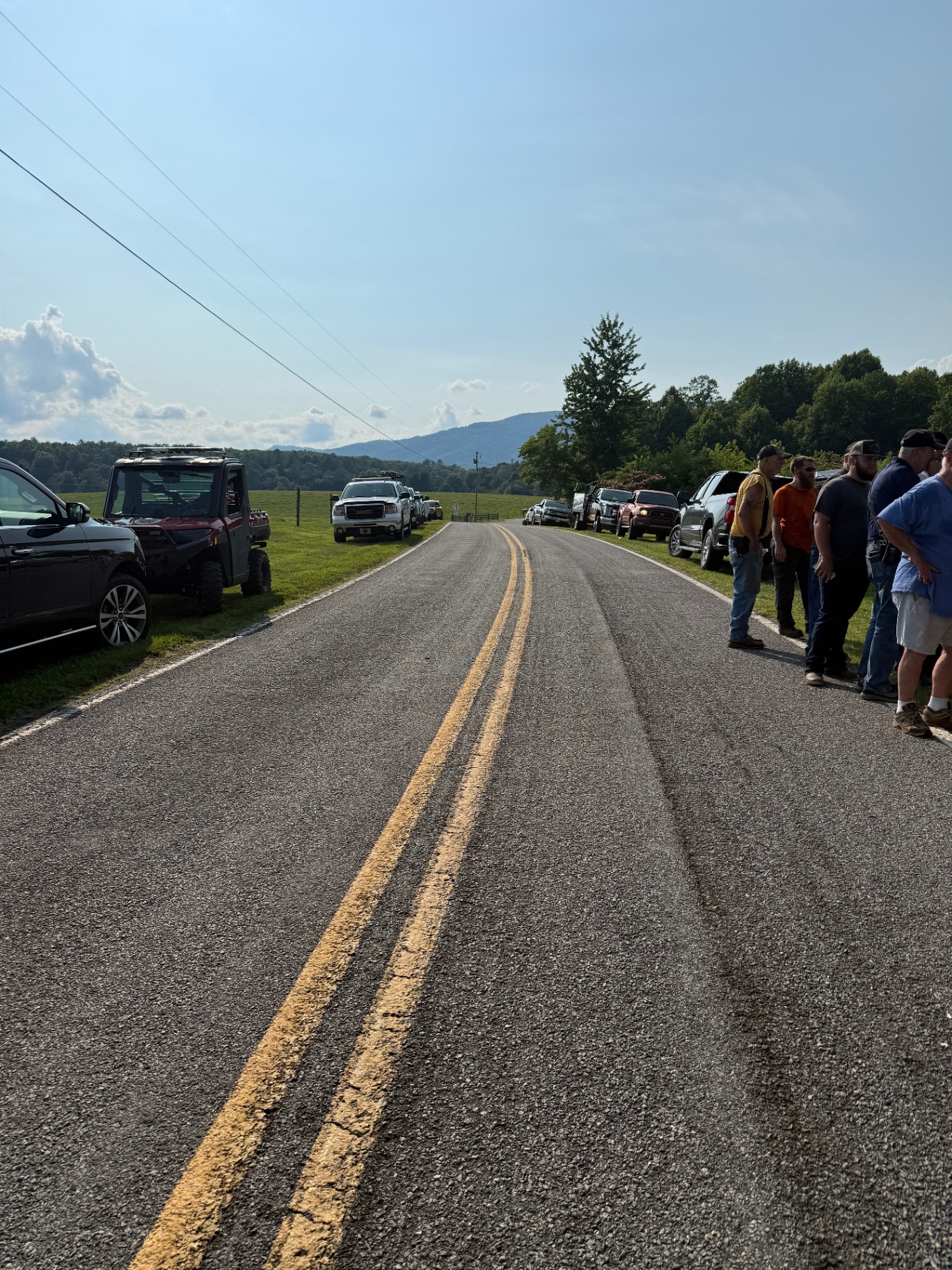 Vehicles lined along a rural road during a search operation